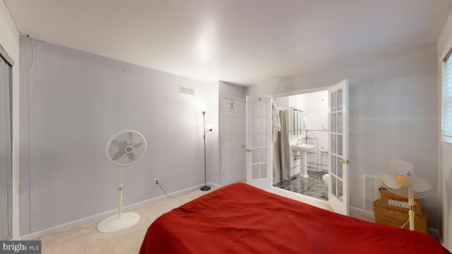 carpeted bedroom with french doors and ensuite bathroom