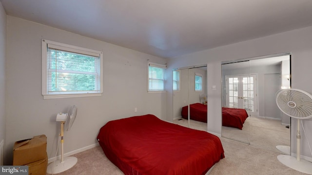 bedroom with carpet, french doors, and two closets