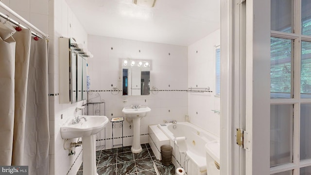 bathroom with a tub, sink, and tile walls