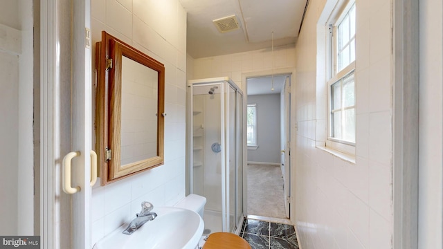 bathroom featuring tile walls, sink, and an enclosed shower