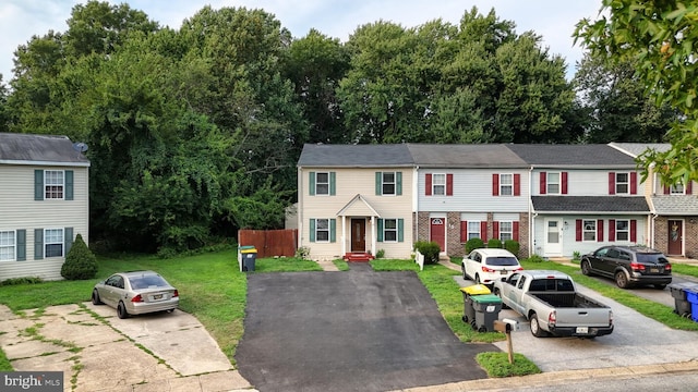 townhome / multi-family property featuring a front lawn