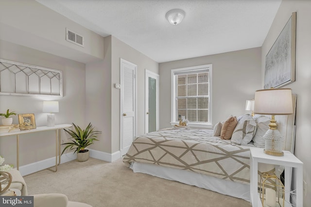 carpeted bedroom with a textured ceiling and a closet