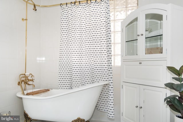 bathroom with tile walls and a tub to relax in