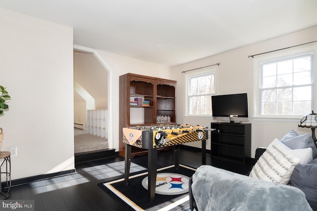 recreation room with a baseboard radiator and dark wood-type flooring