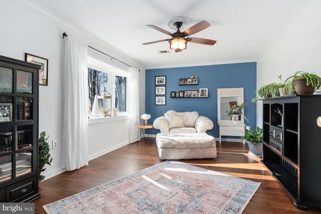 sitting room with ceiling fan, ornamental molding, and dark hardwood / wood-style floors