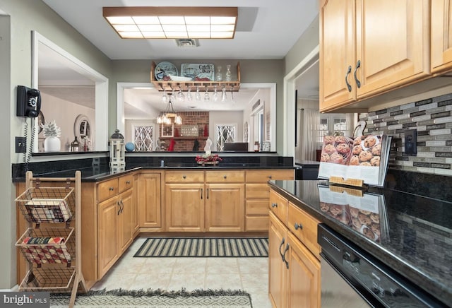 kitchen with dark stone counters, dishwasher, hanging light fixtures, and decorative backsplash