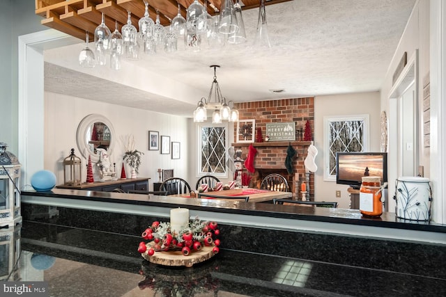 kitchen with a brick fireplace and a textured ceiling