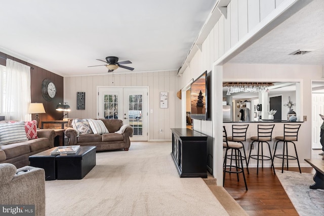 living room featuring hardwood / wood-style floors, plenty of natural light, french doors, and ceiling fan