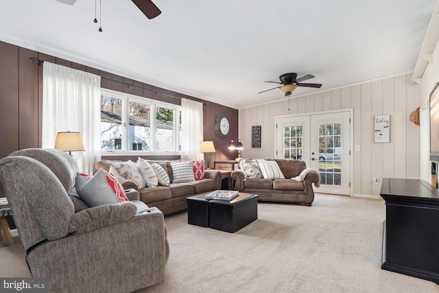 carpeted living room featuring french doors and ceiling fan