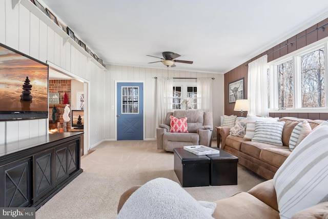 carpeted living room with ornamental molding and ceiling fan