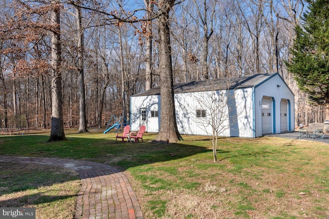 view of yard with a playground, a garage, and an outbuilding