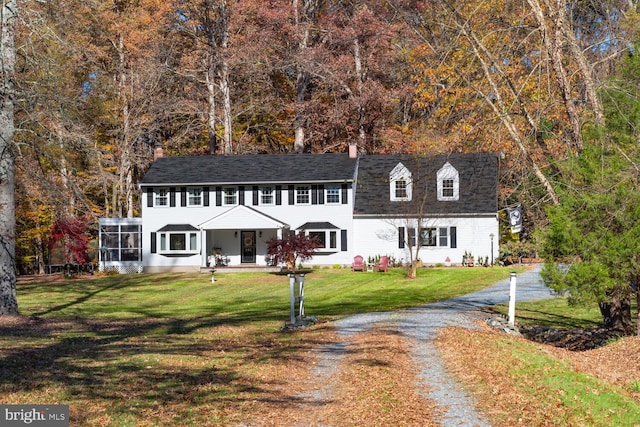 view of front of home with a front yard and a sunroom