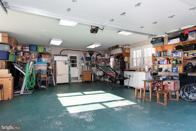 garage with white refrigerator and a garage door opener