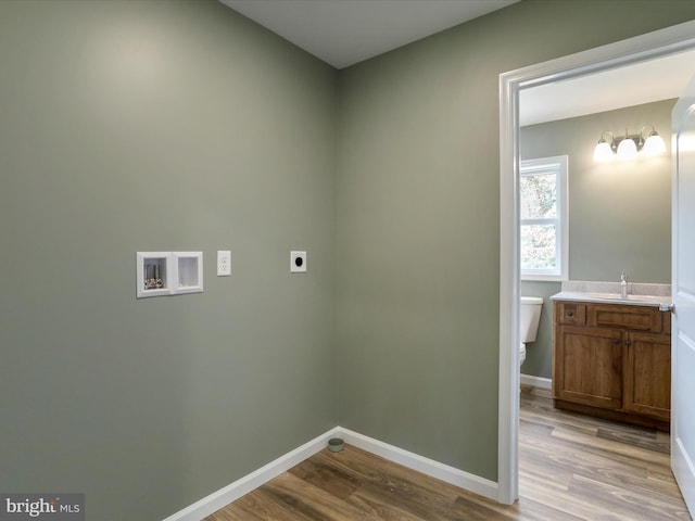 laundry area featuring light wood-style floors, hookup for a washing machine, electric dryer hookup, and baseboards