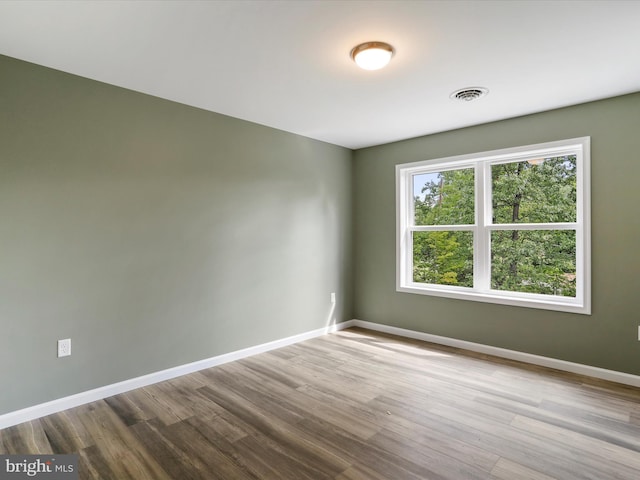 unfurnished room with light wood finished floors, baseboards, and visible vents