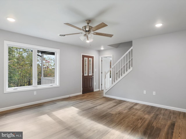 foyer entrance with stairs, ceiling fan, wood finished floors, and baseboards