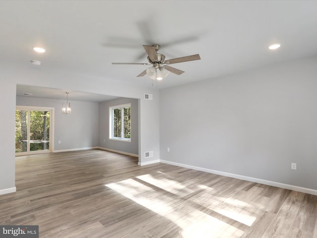 unfurnished room featuring a wealth of natural light, visible vents, light wood-style flooring, and baseboards