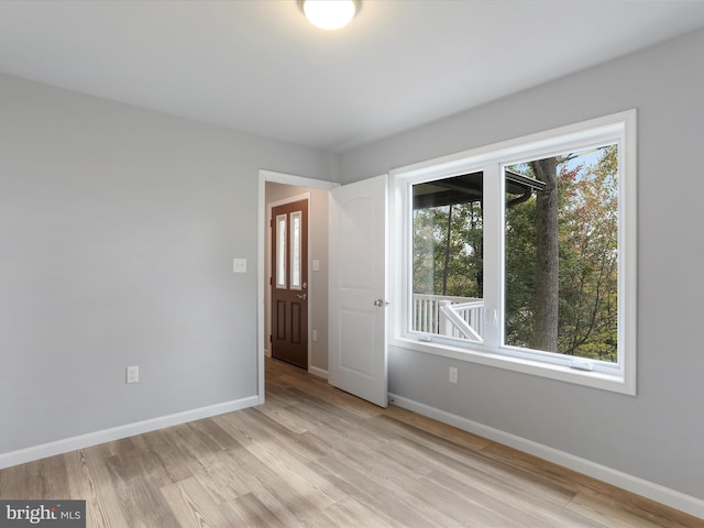 unfurnished room with light wood-style flooring and baseboards