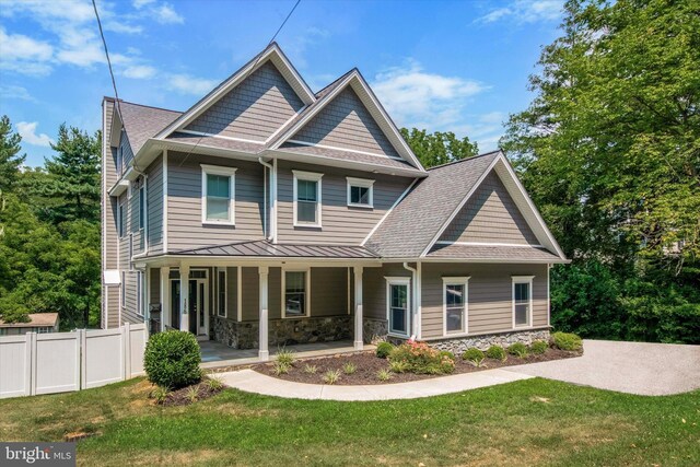 craftsman inspired home featuring a front lawn and covered porch