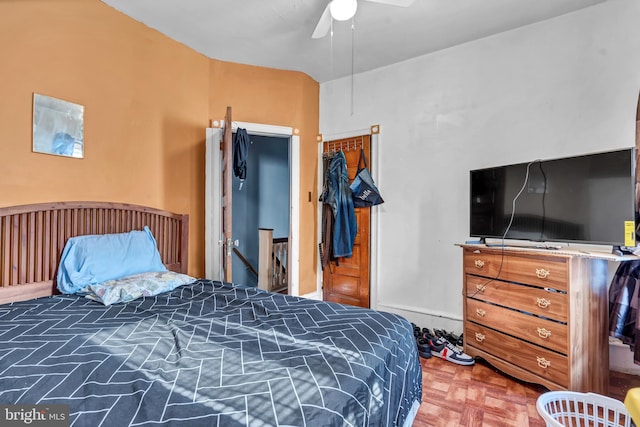 bedroom with ceiling fan and dark parquet flooring