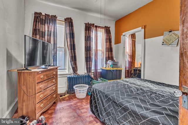 bedroom featuring parquet floors and radiator heating unit