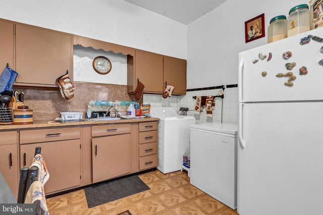 kitchen with white fridge, washer / clothes dryer, backsplash, refrigerator, and light parquet flooring