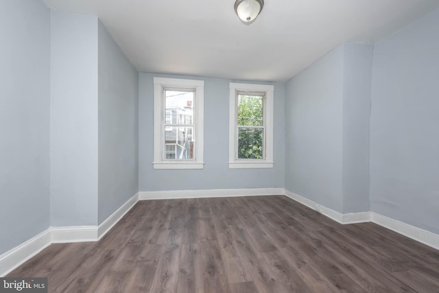 empty room with dark hardwood / wood-style flooring