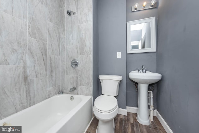 full bathroom featuring sink, tiled shower / bath combo, wood-type flooring, and toilet