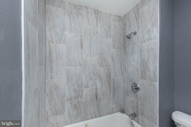 bathroom with tiled shower / bath and toilet