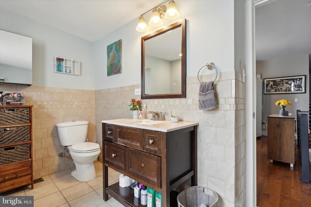 bathroom featuring tile walls, wood-type flooring, and toilet