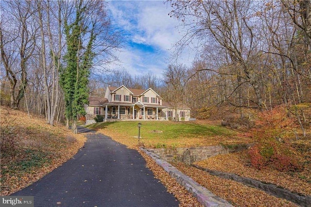 cape cod house featuring a front yard