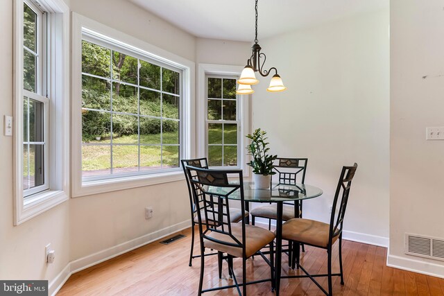 unfurnished room featuring french doors, a chandelier, and light hardwood / wood-style floors