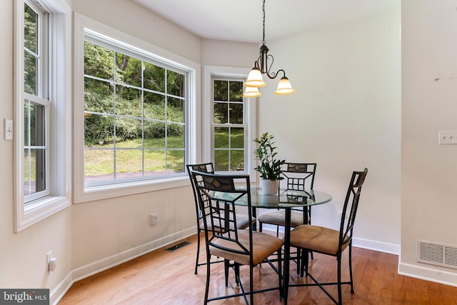 dining room with wood-type flooring and a notable chandelier