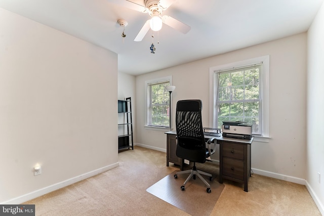 carpeted office space with ceiling fan