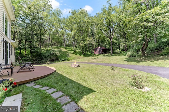 view of yard with an outdoor fire pit and a shed