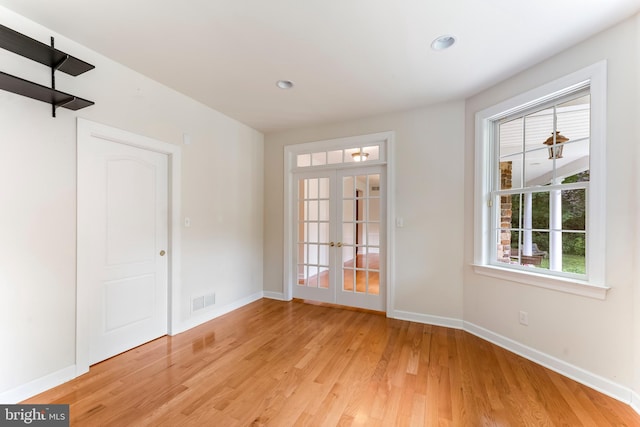 empty room with french doors and light wood-type flooring