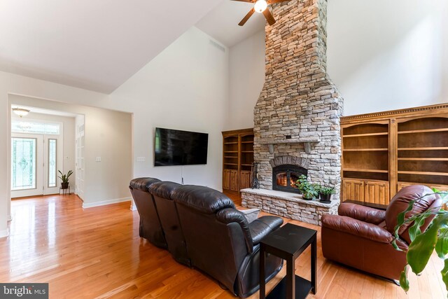 living room featuring ceiling fan, light hardwood / wood-style flooring, a fireplace, and a healthy amount of sunlight