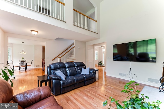 living room with high vaulted ceiling, a fireplace, ceiling fan, and light hardwood / wood-style floors