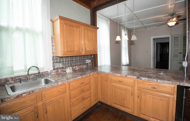 kitchen with ceiling fan, pendant lighting, sink, dark wood-type flooring, and decorative backsplash