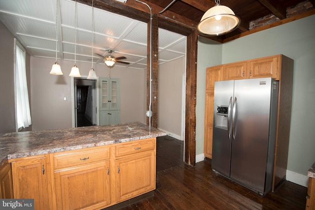 kitchen featuring dark wood-type flooring, beam ceiling, hanging light fixtures, ceiling fan, and stainless steel fridge