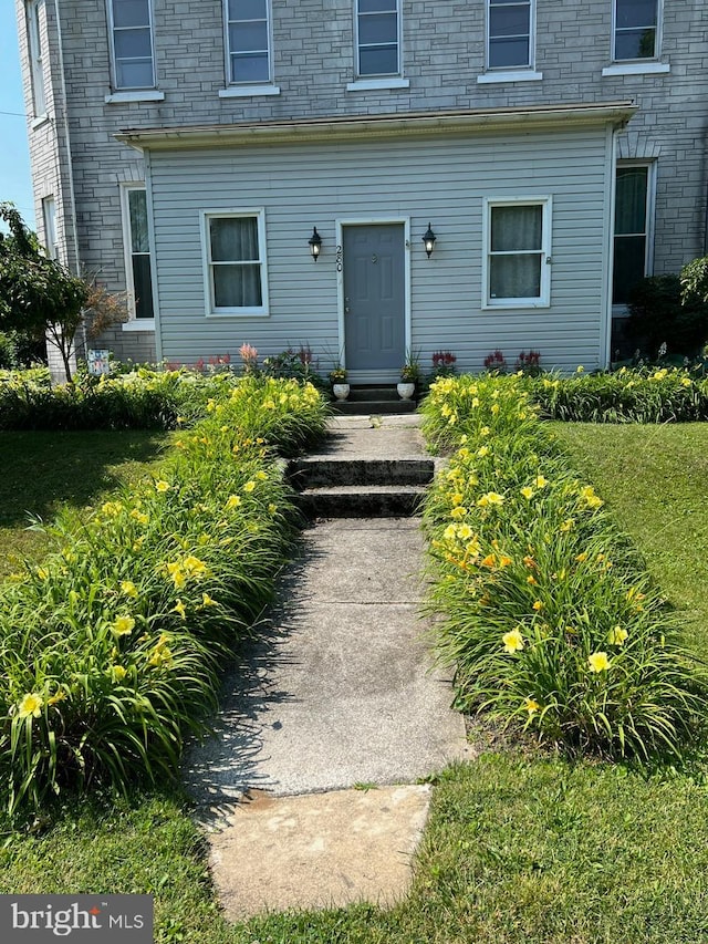 doorway to property with a yard