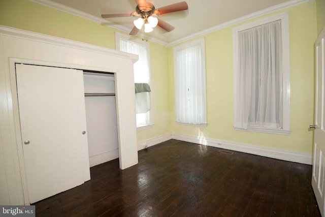 unfurnished bedroom with a closet, ceiling fan, dark wood-type flooring, and crown molding