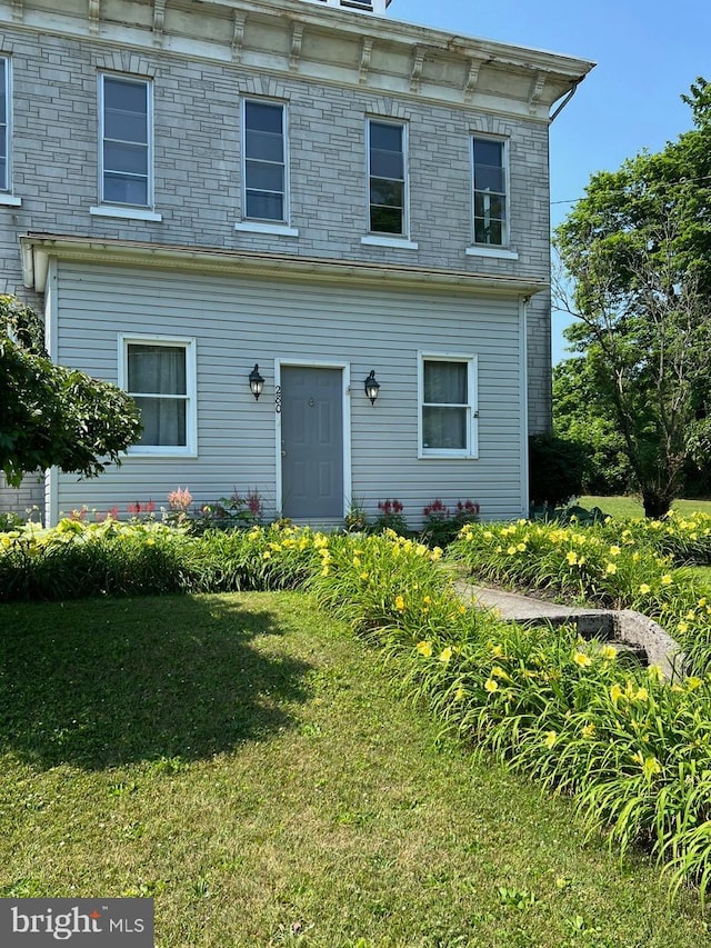 italianate-style house featuring a front lawn