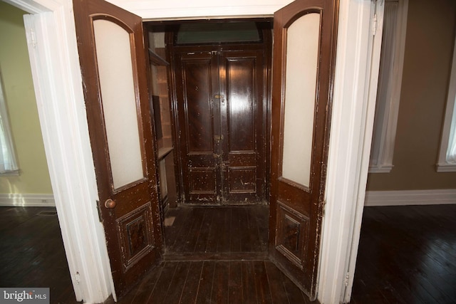 hallway with dark hardwood / wood-style flooring