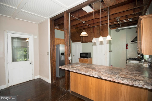 kitchen featuring dark wood-type flooring, stainless steel fridge with ice dispenser, sink, decorative light fixtures, and stone countertops