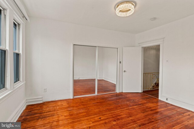 unfurnished bedroom with hardwood / wood-style floors and a closet