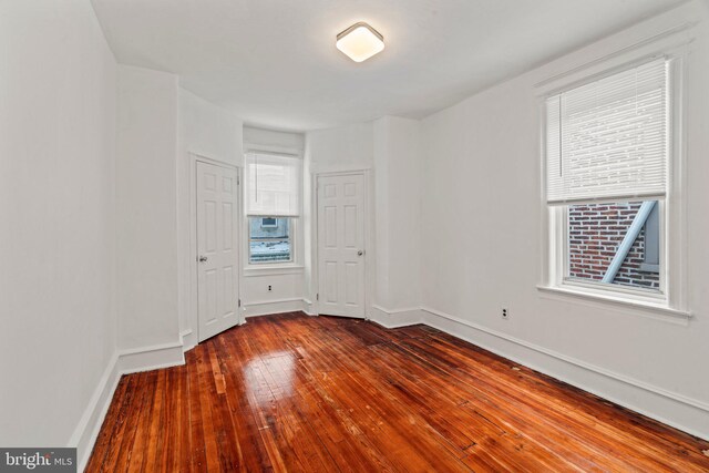 unfurnished room with hardwood / wood-style flooring and a healthy amount of sunlight