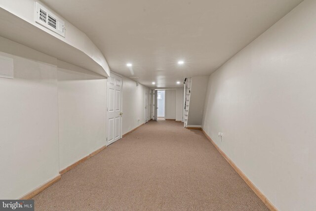 corridor featuring light colored carpet