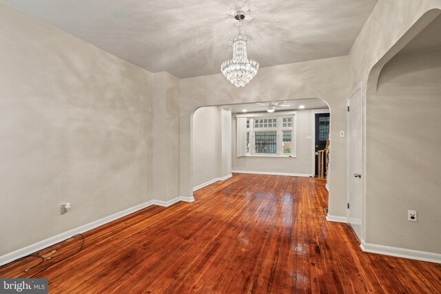 unfurnished living room with hardwood / wood-style floors and a chandelier