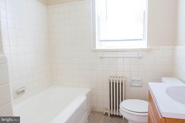 bathroom with toilet, vanity, radiator, tile walls, and a bathtub